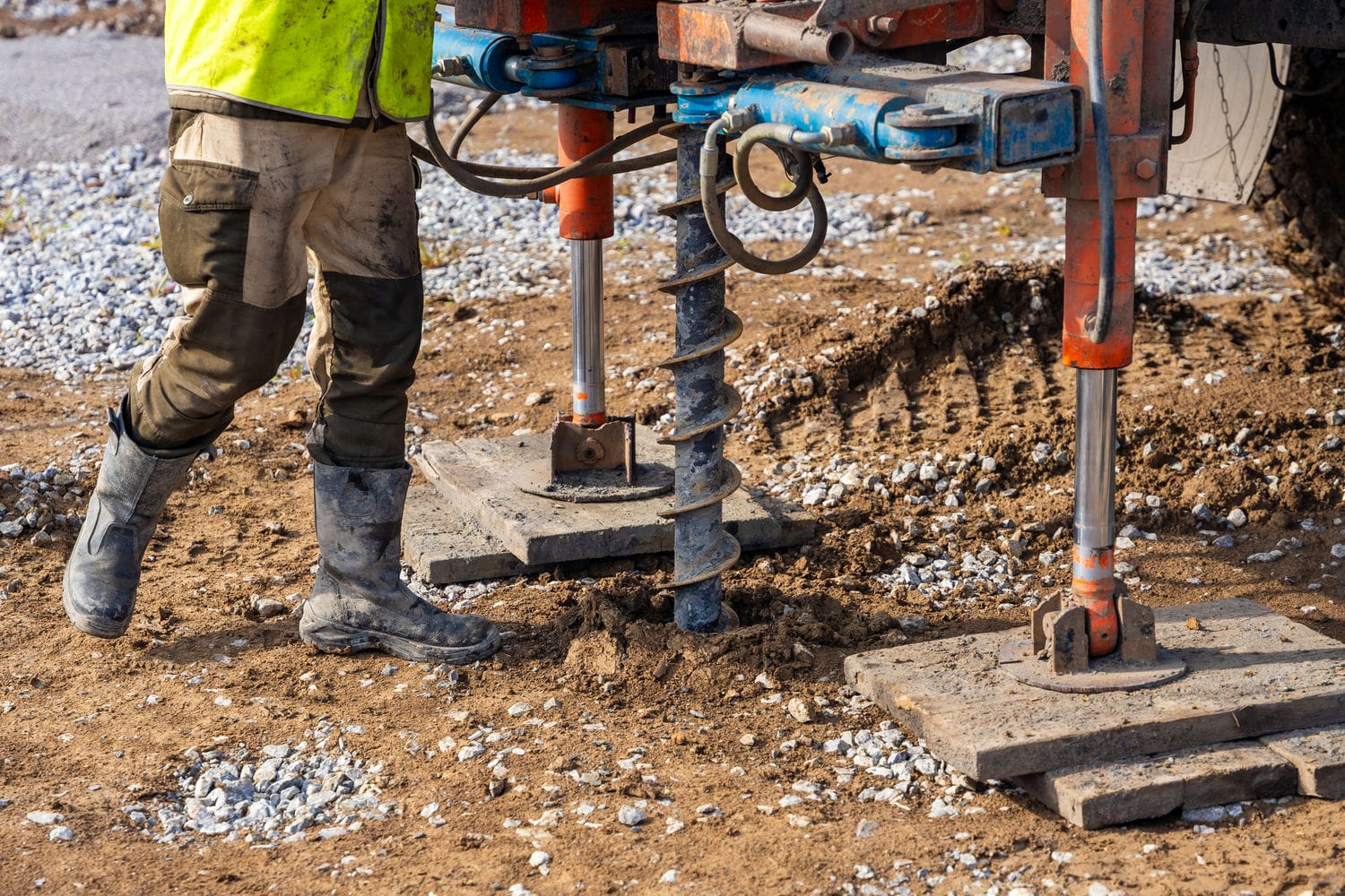 Compact drill rig taking soil samples on a flat residential lot during a custom home soils test in the BC Lower Mainland.